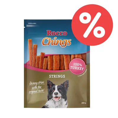 Rocco Chings Strings, 100% pavo, 200 g. Tiras finas con el sabor original. Envase con imagen de perro y símbolo de porcentaje rojo. Rocco Chings Strings, 100% pavo, 200 g. Tiras finas con el sabor original. Envase con imagen de perro y símbolo de porcentaje rojo.