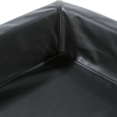 Primo piano di una superficie in pelle nera liscia con cuciture sull’angolo. Dettagli del materiale per la descrizione del prodotto.