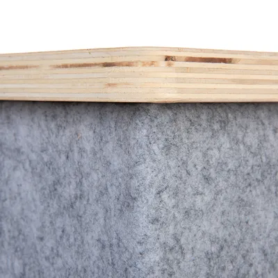 Detailný záber na drevenú dosku s sivým filcovým poťahom, ukazuje kombináciu materiálov pre nábytok alebo doplnky.