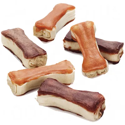 Varios snacks en forma de hueso para perros, con capas visibles de diferentes colores marrón y beige. No se muestra marca ni texto en el producto.