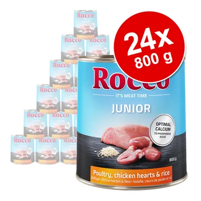 Rocco Junior, 24 konzerv po 800 g. Vidno: perutnina, piščančja srca in riž. Oznaka: optimalno razmerje kalcija in fosforja. Besedilo v angleščini: Poultry, chicken hearts & rice.