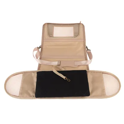 Siège de transport beige pour animal, ouvert avec sangle réglable, coussin noir matelassé, poches latérales en maille et attache métallique visible au centre.