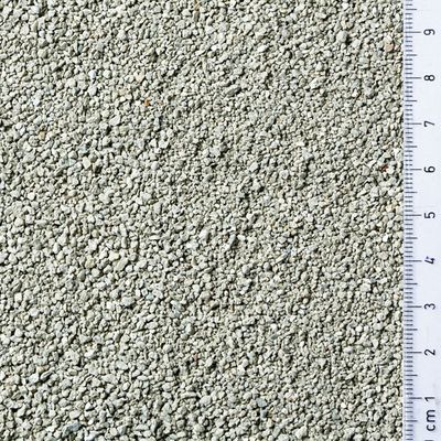 Granuli grigi di lettiera per gatti con righello a destra che mostra dimensioni dei granuli da 1 a 9 cm.