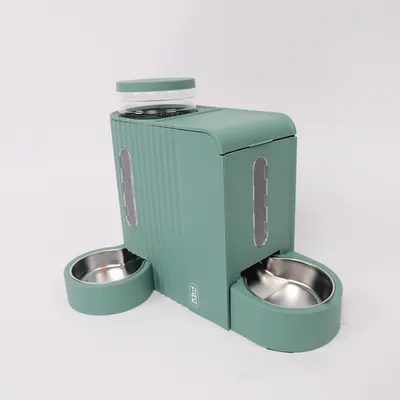 Distributore di cibo verde con due ciotole in acciaio inox e coperchio trasparente per crocchette. Finestre laterali per controllare il livello di riempimento.