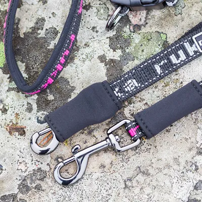 Hundesnor af sort nylon med pink accenter og forkromet karabinhage, egnet til sikkert greb.