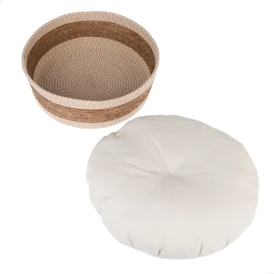 Kulatý koš z pleteného přírodního materiálu s vyjímatelným bílým polštářem.