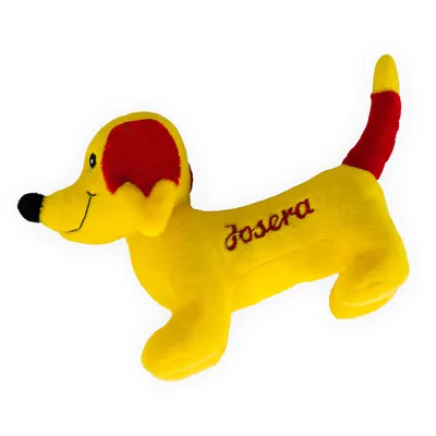 Geel pluchen speelgoed in de vorm van een hond met rode oren en staart, geborduurd met het opschrift 'Josera'.