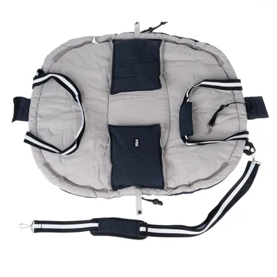 Sac de transport gris et bleu TIAKI avec deux poches extérieures, poignées à rayures noires et blanches, sangle d’épaule réglable et mousqueton visible.