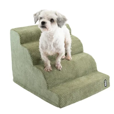 Petit chien blanc sur escalier pour animaux à trois marches, revêtement tissu vert texturé, étiquette noire avec texte blanc TIAKI visible en bas à droite.