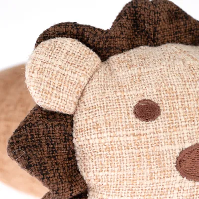 Närbild av ett gosedjur i lejonform av beige och brunt jute med broderade ögon och nos.
