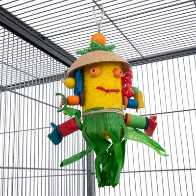 Farebná vtáčia hračka z prírodných materiálov, visiaca v klietke. Obsahuje drevo, lýko a plastové prvky v rôznych farbách.