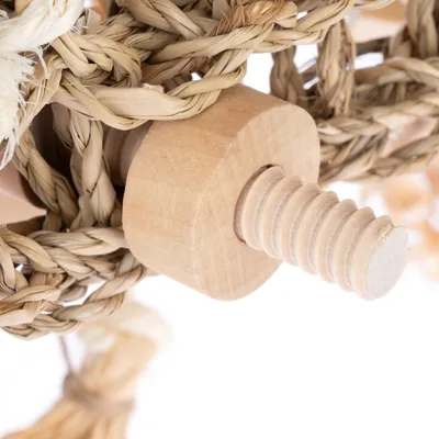 Nærbillede af en trægevind med flettede naturfibre, egnet til fastgørelse af legetøj eller tilbehør.