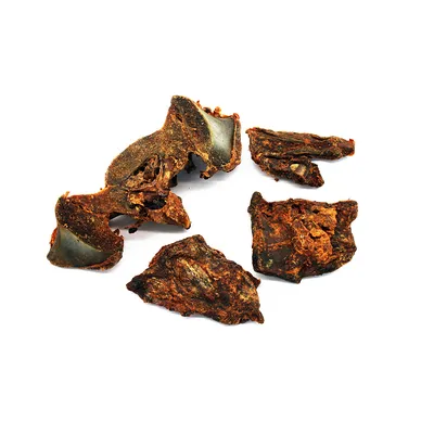 Mehrere getrocknete Fleischstücke mit Knochenanteil, braun und unregelmässig geformt.