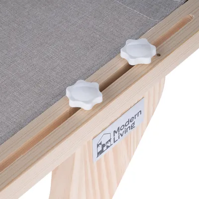 Détail d’un meuble en bois avec surface en tissu gris, deux boutons de réglage blancs et étiquette visible : Modern Living.