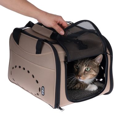 Transportní taška Tiaki s síťovaným otvorem, béžová, kočka uvnitř. Ruka otevírá horní víko. Viditelné ventilační otvory a držadlo.