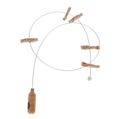 Jouet pour chat avec poignée en liège, fil métallique et éléments torsadés en papier, perle en bois à l’extrémité. Marque TIAKI visible sur la poignée.