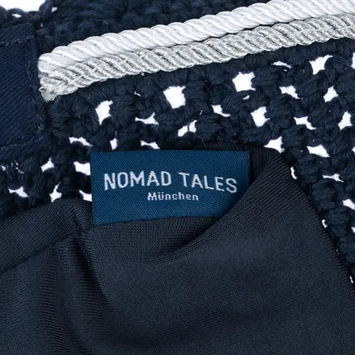 Nomad Tales München. Donkerblauwe stof met gehaakt patroon en zilveren koord.