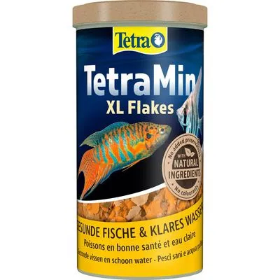 TetraMin XL Flakes, met tekst: 'with natural ingredients', 'No added preservatives', 'No colorants', 'GESUNDE FISCHE & KLARES WASSER'. Visvlokken zichtbaar in de verpakking.