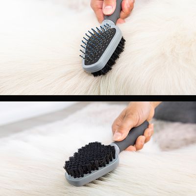 Escova de dois lados com nódulos e cerdas, mostrada na higiene do pelo de um animal branco. Lado superior para desembaraçar, lado inferior para brilho e limpeza.