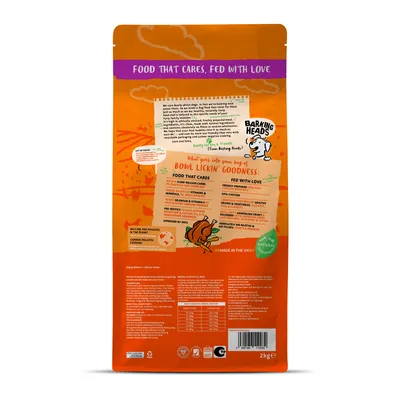 Back of pet food bag showing feeding guide, ingredient highlights such as slow-release carbs, vitamins, prebiotics, and 50% chicken, plus care claims and nutritional information table.