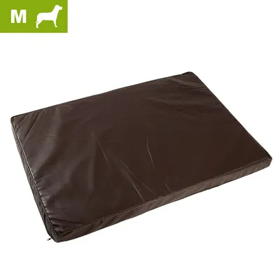Coussin rectangulaire marron pour chien, taille M indiquée dans un encadré vert en haut à gauche. Housse aspect cuir ou simili, surface lisse sans motifs visibles.