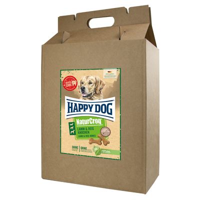 Happy Dog NaturCroq Lamm & Reis Knochen -koiranherkut, ruskea pahvipakkaus, etiketissä koiran kuva ja tekstiä saksaksi sekä englanniksi. Dental Care -merkintä näkyvissä.