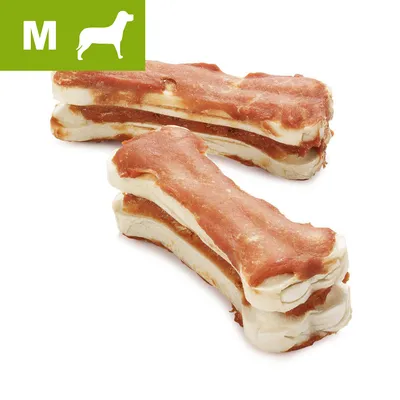 Three medium-sized bone-shaped chews with a brown outer layer and white inner layer, green label in corner with letter M and dog silhouette indicating medium size.