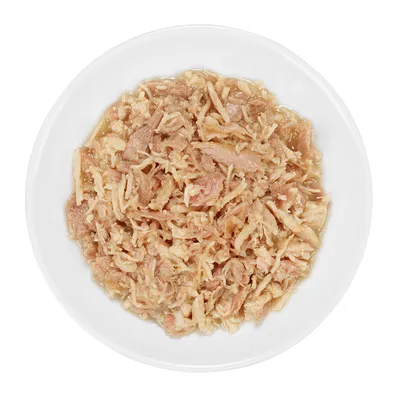 Nahaufnahme von zerkleinertem Fleisch in einer weissen Schale, vermutlich Nassfutter für Haustiere.
