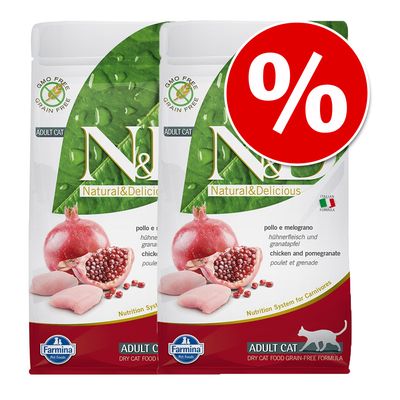 Două pungi Farmina N&D Natural & Delicious Adult Cat, Chicken and Pomegranate, cu etichetă promoțională roșie cu simbol procent. Text vizibil: GMO Free, Grain Free, Italian Formula.