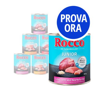 Rocco Junior, lattina da 800 g con tacchino, cuori di vitello e riso. Etichetta: 'Supports healthy growth'. Testo promozionale in cerchio blu: PROVA ORA.