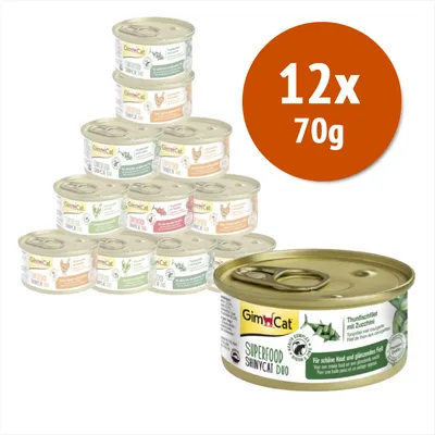 12 lattine da 70 g di GimCat Superfood ShinyCat Duo, vari gusti visibili sulle etichette. In primo piano una lattina con testo: Tonno con zucchine, per pelle sana e pelo lucente.