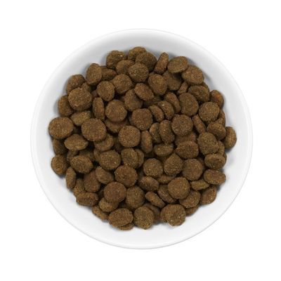 Miska z suchą karmą w formie brązowych, okrągłych granulek. Brak widocznych marek lub tekstu na produkcie.