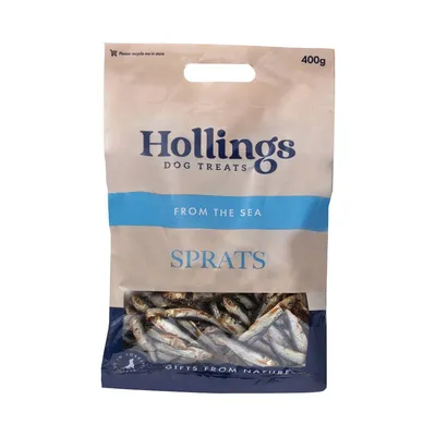 Bag labelled Hollings Dog Treats, From the Sea, Sprats, 400g. Visible dried fish inside packaging. Text: Please recycle me in store, Gifts from Nature. Bag labelled Hollings Dog Treats, From the Sea, Sprats, 400g. Visible dried fish inside packaging. Text: Please recycle me in store, Gifts from Nature.