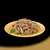 Chunks of meat with green peas and orange vegetable pieces served on a yellow plate, shown as a serving suggestion for pet food.