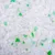 Witte en groene korrels kattenbakvulling, close-up van het productmateriaal zonder verpakking of merknaam zichtbaar.