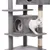 Grey cat tree with multiple levels, a cave, and a white cat model looking out from the cave. Sisal-wrapped post visible.