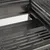 Gros plan sur le fond d'une cage en métal noir avec grille et bac amovible visible, sans accessoires ni animaux.