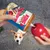 KONG Stuff'n recheio de manteiga de amendoim colocado num dispensador de brinquedos KONG vermelho. Cão visível ao fundo.