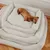 Gestapeltes cremefarbenes Hundebett aus geripptem Stoff, mit einem schlafenden braunen Hund auf dem obersten Bett.