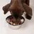 Perro marrón come comida húmeda de un cuenco plateado.