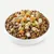 Bowl filled with dry pet food kibble topped with diced vegetables and meat pieces, showing serving suggestion for mixed pet food.