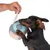 Chien tenant une balle en tissu avec poignée en corde, attrapée par une main humaine. Jouet pour chien visible en utilisation.