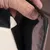 Close-up of a hook-and-loop fastener on brown fabric, open and held by a hand.