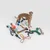 Chien debout entouré de jouets pour chien variés : balles, cordes, objets en caoutchouc, peluches et accessoires de différentes formes et couleurs, posés au sol.