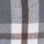 Close-up of a checked fabric pattern in grey, white and brown. Shows the texture of the material.