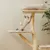 Kratzbaum aus Holz mit Sisalseil, zwei gepolsterte Liegeflächen und Spielball. Katze nutzt den Kratzbaum.