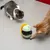 Two cats playing with a green interactive toy that dispenses treats.