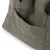 Vue rapprochée d’un sac en tissu avec une grande poche extérieure et une étiquette en cuir cousue sur le devant, bouton pression visible à l’intérieur de la poche.