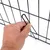 Main tenant une tige métallique pour fixer un panneau de grille en métal noir, détail du système d’assemblage visible.