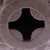 Close-up of a brown surface with a cross-shaped opening in the centre, possibly part of a toy or accessory.